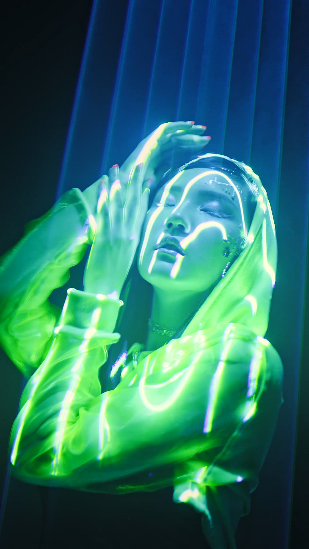 A dancer moving under green neon light